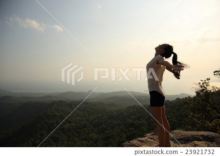 fitness woman open arms at mountain peak cliff fitness woman open arms at mountain peak cliff 23921732