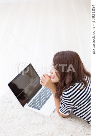 婦女屏幕觀看個人計算機在屋子裡 婦女屏幕觀看個人計算機在屋子裡 23921854