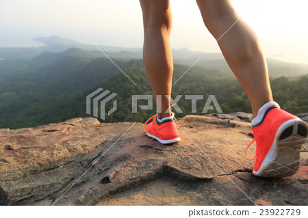 young healthy woman legs on mountain peak rock 23922729