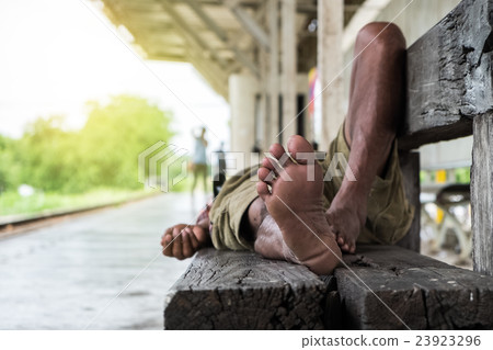 homeless man sleeping at train station 23923296