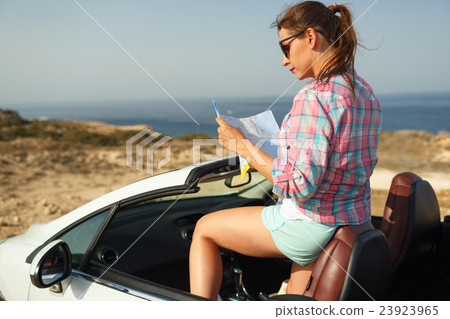 Young pretty woman see the map near the cabriolet Young pretty woman see the map near the cabriolet 23923965