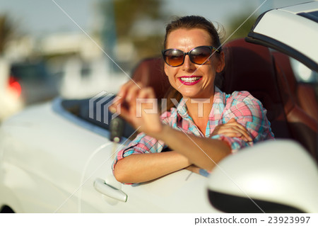 Woman sitting in a car with the keys in hand Woman sitting in a car with the keys in hand 23923997