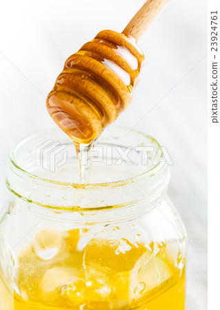 Honey flowing from wooden stick. Honey flowing from wooden stick. 23924761