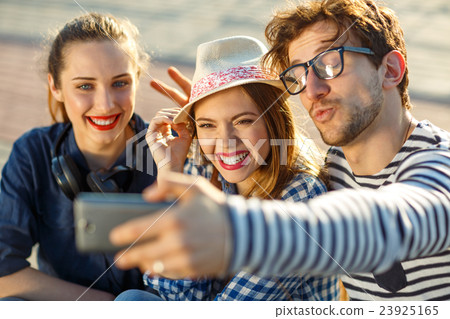 Smiling friends making selfie outdoors 23925165