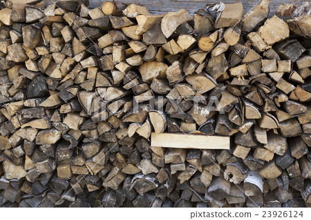 A pile of firewood at the wall of the wooden house A pile of firewood at the wall of the wooden house 23926124