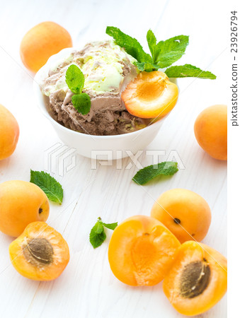 Ice cream with apricots and mint on a white 23926794
