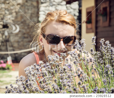 Young joyful woman posing with lavender flowers Young joyful woman posing with lavender flowers 23928512