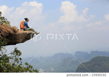 young woman hiker at mountain peak cliff.. 23930191