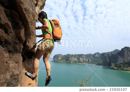 young woman rock climber climbing at seaside rock 23930197