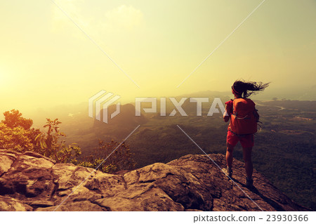 young woman hiker hiking on mountain peak cliff 23930366