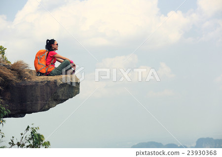 young woman hiker hiking on mountain peak cliff young woman hiker hiking on mountain peak cliff 23930368
