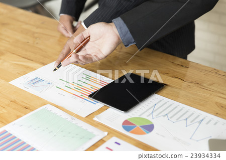 businessman analyzing with tablet and paperwork d 23934334