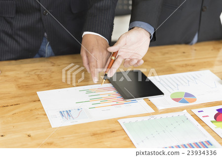 businessman analyzing with tablet and paperwork d 23934336