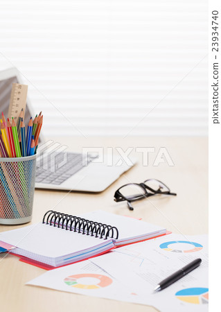 Office workplace with laptop, reports and pencils 23934740