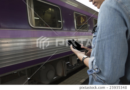 woman holding smartphone backpack at train station woman holding smartphone backpack at train station 23935348