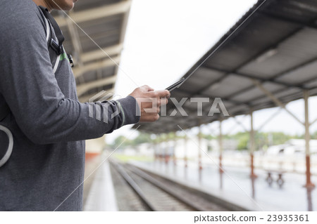 man holding smartphone backpack at train station man holding smartphone backpack at train station 23935361