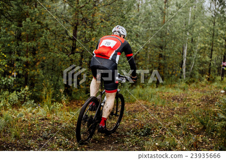 male athlete middle-aged rides in forest male athlete middle-aged rides in forest 23935666