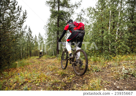 male athlete riding through in forest male athlete riding through in forest 23935667