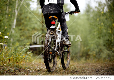 dirty wheel and feet of athlete mountainbiker 23935669