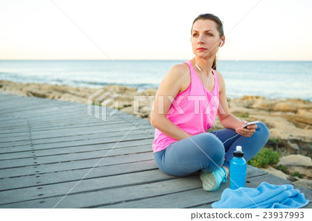 Woman resting after jogging on a wooden path 23937993