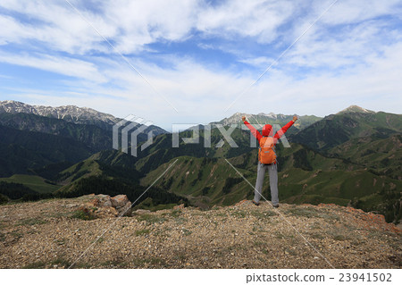 woman backpacker open arms on mountain peak woman backpacker open arms on mountain peak 23941502