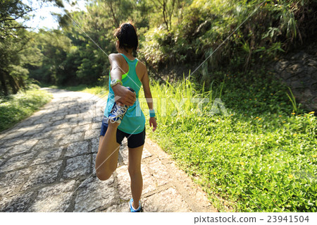 young woman trail runner warm up on country road 23941504