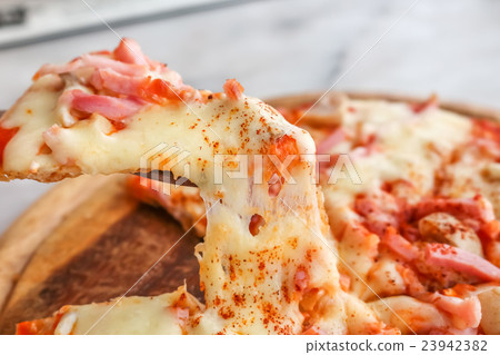 Hot pizza slice with melting cheese Hot pizza slice with melting cheese 23942382