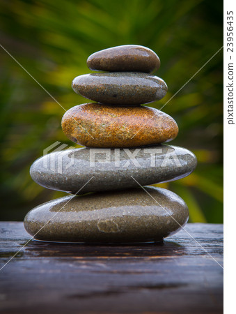 stack of round smooth wet pebbles  23956435