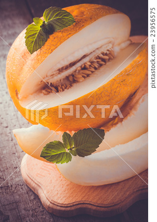 Fresh sweet orange melon on the wooden table 23956575