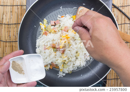 Chef putting salt and pepper in cooking fried rice 23957800