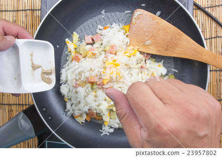 Chef putting salt and pepper in fried rice Chef putting salt and pepper in fried rice 23957802