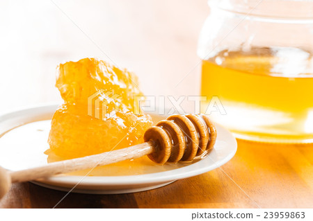 Wooden honey stick and honeycomb. 23959863