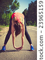 Young fitness woman runner stretching before run 23965159