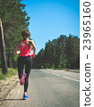 Young fitness woman running on forest trail 23965160