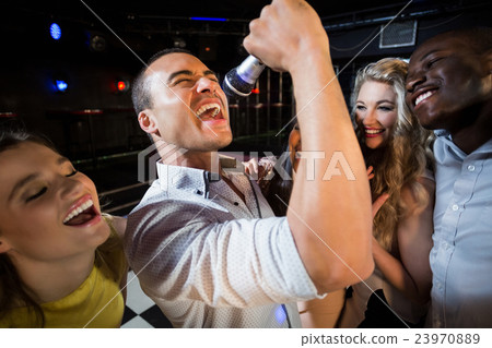 Happy friends singing at the karaoke 23970889