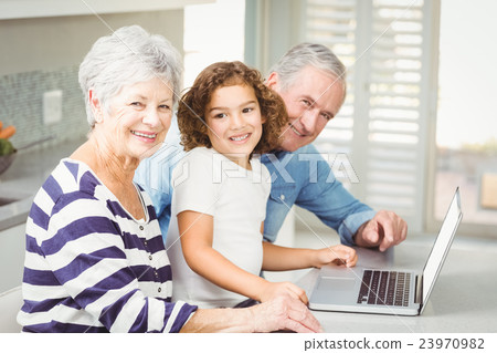 Portrait of happy girl with grandparents using laptop Portrait of happy girl with grandparents using laptop 23970982