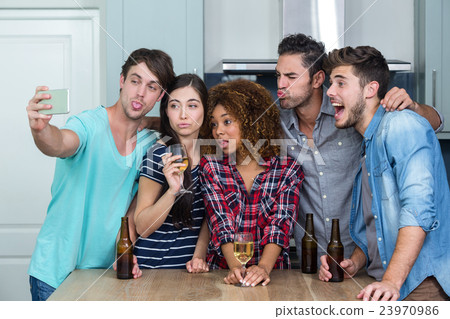 Multi-ethnic young friends making faces while taking selfie 23970986
