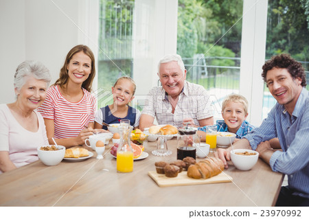 Multi-generation family sitting at table during breakfast Multi-generation family sitting at table during breakfast 23970992