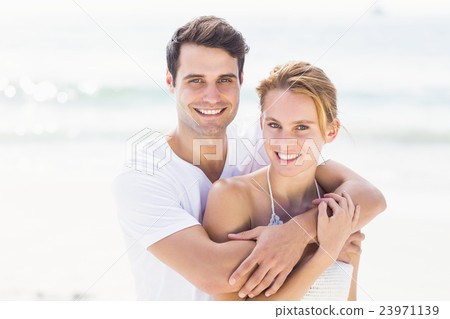 Portrait of young couple embracing each other on the beach 23971139