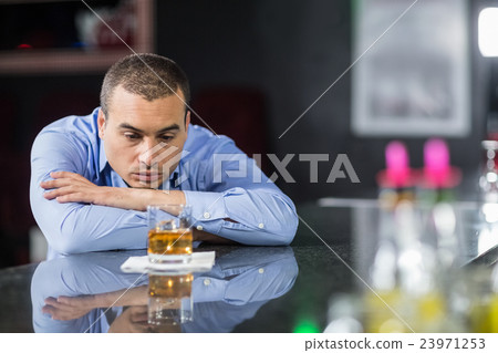 Depressed businessman looking at whisky glasses 23971253