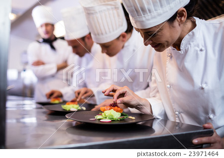 Chef decorating a food plate Chef decorating a food plate 23971464