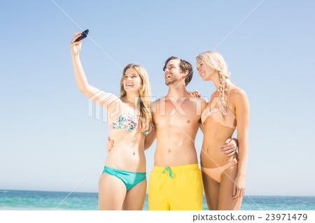 Young friends taking a selfie on the beach 23971479