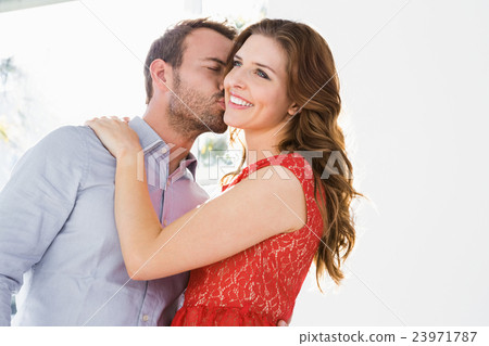 Man kissing woman on cheek 23971787