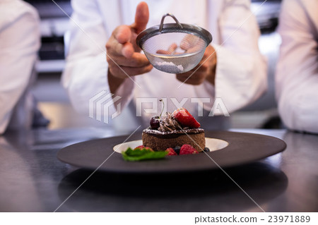 Chefs team finishing dessert plates Chefs team finishing dessert plates 23971889