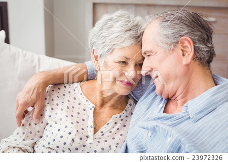 High angle view of romantic senior couple sitting on sofa High angle view of romantic senior couple sitting on sofa 23972326