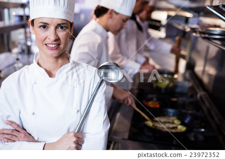 Portrait of chef holding a ladle 23972352