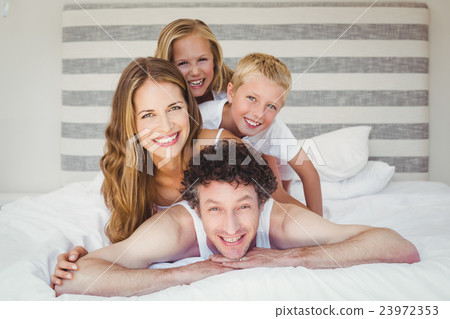 Portrait of smiling happy family on bed 23972353