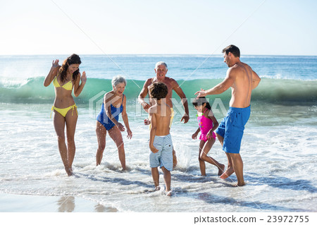 Happy family playing with waves Happy family playing with waves 23972755