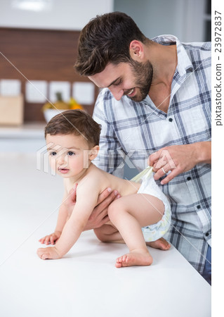 Father checking diaper of son Father checking diaper of son 23972837