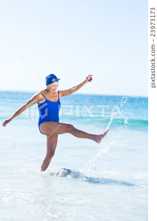 Pretty mature woman playing on the beach Pretty mature woman playing on the beach 23973173